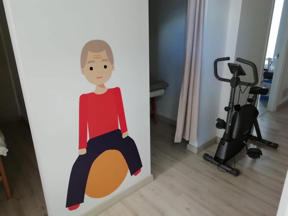 Stanza trattamenti con cyclette riabilitativa e illustrazione anatomica